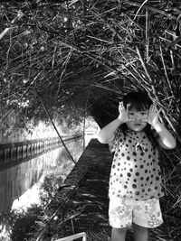 Portrait of girl gesturing while standing by canal