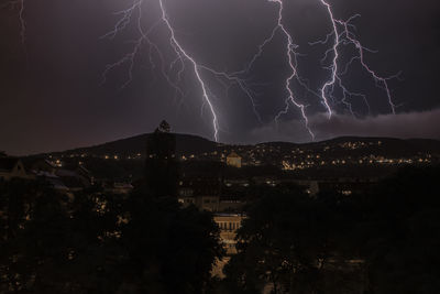 Low angle view of illuminated cityscape against sky at night