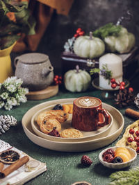 A cup of coffee lattee with pastry, served on plate. stilllife photography with winter vibes concept