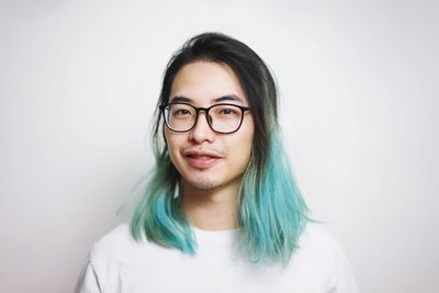 Portrait of smiling young woman against white background