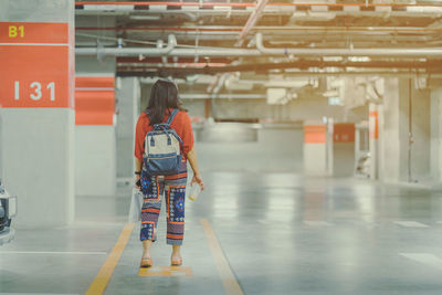 Rear view of woman walking in corridor of building