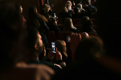 Spectators sit in the hall and watch a concert. people in the auditorium watching the performance. 