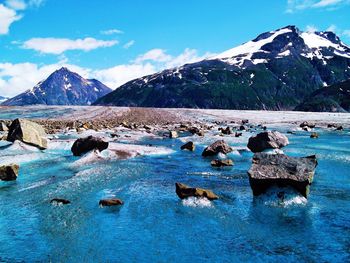 Scenic view of sea and snowcapped mountains against sky