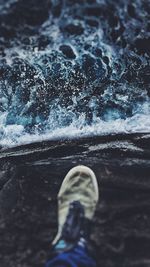 Low section of person against sea on rocks