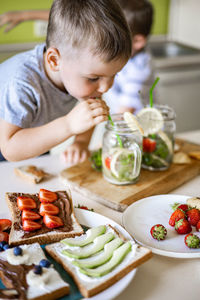 Close-up of boy eating food at home