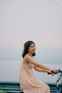 Beautiful woman standing by sea against sky