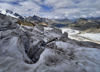 Scenic view of glacier and snowcapped mountains  against sky