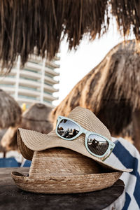 Close-up of sunglasses with hats on table at beach