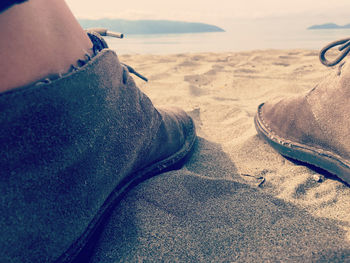 Low section of person son sand at beach