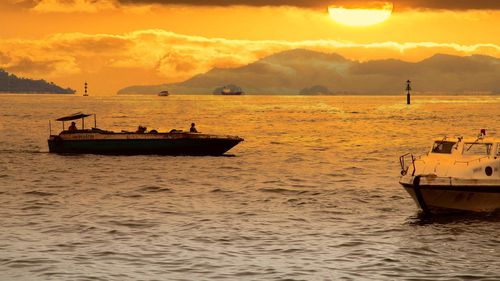 Sailboat on sea against sky during sunset