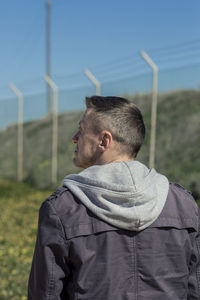 Rear view of man on field against sky