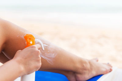 Midsection of woman hand on sand at beach