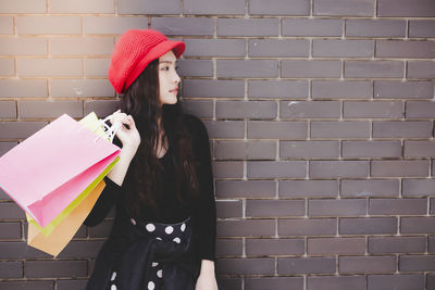 Woman standing against brick wall