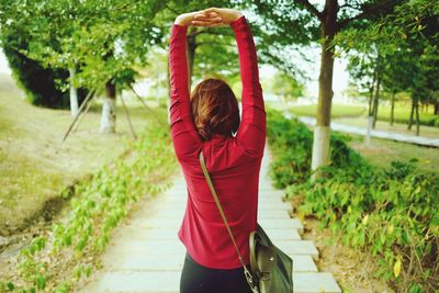 Rear view of woman standing by footpath