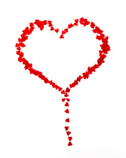 Close-up of red heart shape over white background