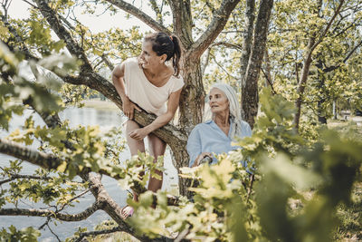 Mother and daughter having fun, climbing a tree