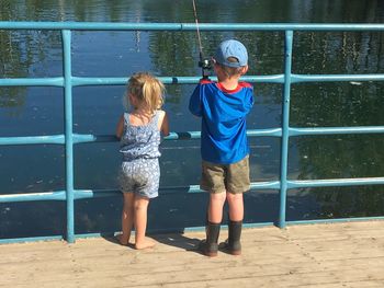 Siblings fishing in lake