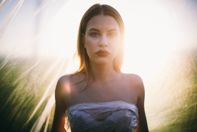 Portrait of young woman against plastic