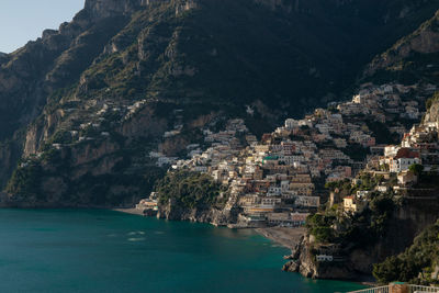 Scenic view of sea by buildings in town