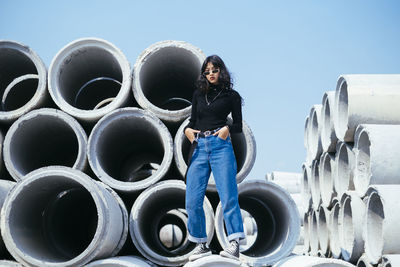 Full length portrait of woman standing against blue sky