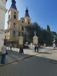 People on street amidst buildings in city