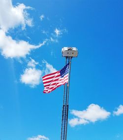 Low angle view of flag against blue sky