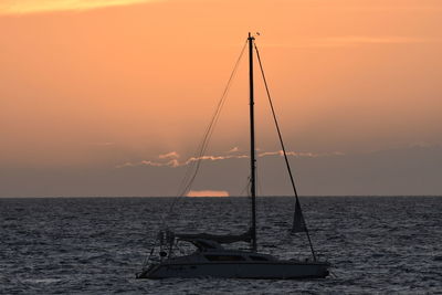 Sailboat on sea against sky during sunset