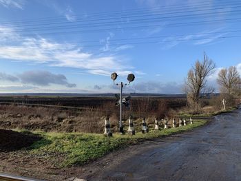 Street amidst field against sky