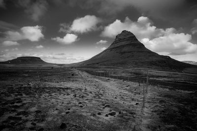 Scenic view of land against cloudy sky