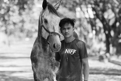 Portrait of man with horse on field