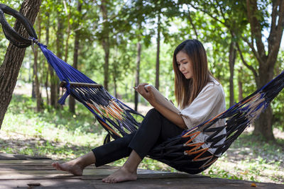 Young woman sitting on hammock