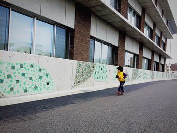 Full length of woman standing in front of building