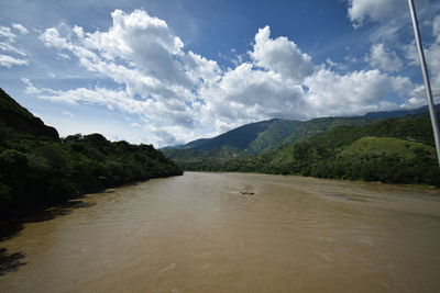 Scenic view of river amidst mountains against sky