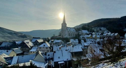 Buildings in town against sky during winter