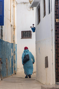 Rear view of man standing against building