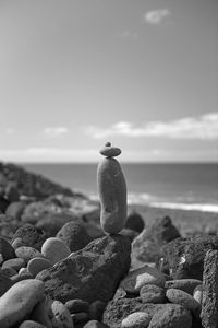 Stone stack at beach against sky