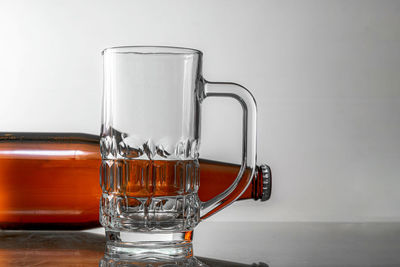 Close-up of beer glass on table against white background