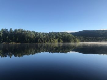 Scenic view of lake against clear blue sky