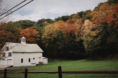 House amidst trees and buildings against sky