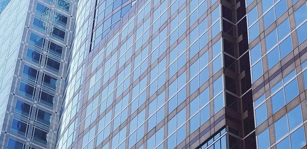 Low angle view of modern glass building in city