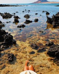 Low section of person on rock at beach