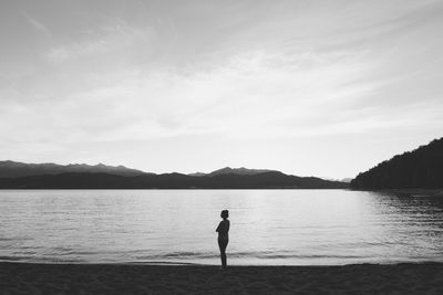 Full length of silhouette woman standing at beach against sky