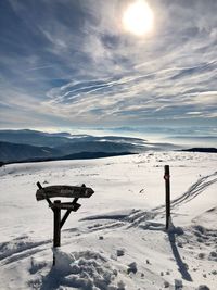 Scenic view of snow covered field against sky