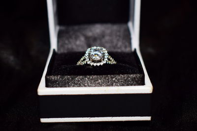 Close-up of diamond ring in box on black background
