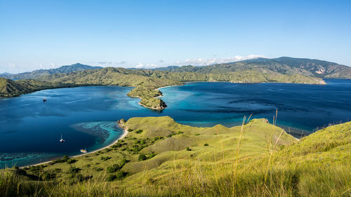 Scenic view of sea and mountains against blue sky