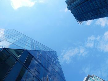 Low angle view of modern building against cloudy sky