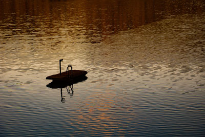 High angle view of silhouette person in lake during sunset