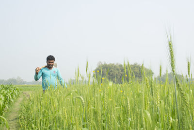 Man standing on field against sky