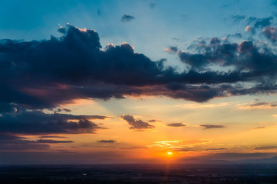 Scenic view of dramatic sky over landscape during sunset