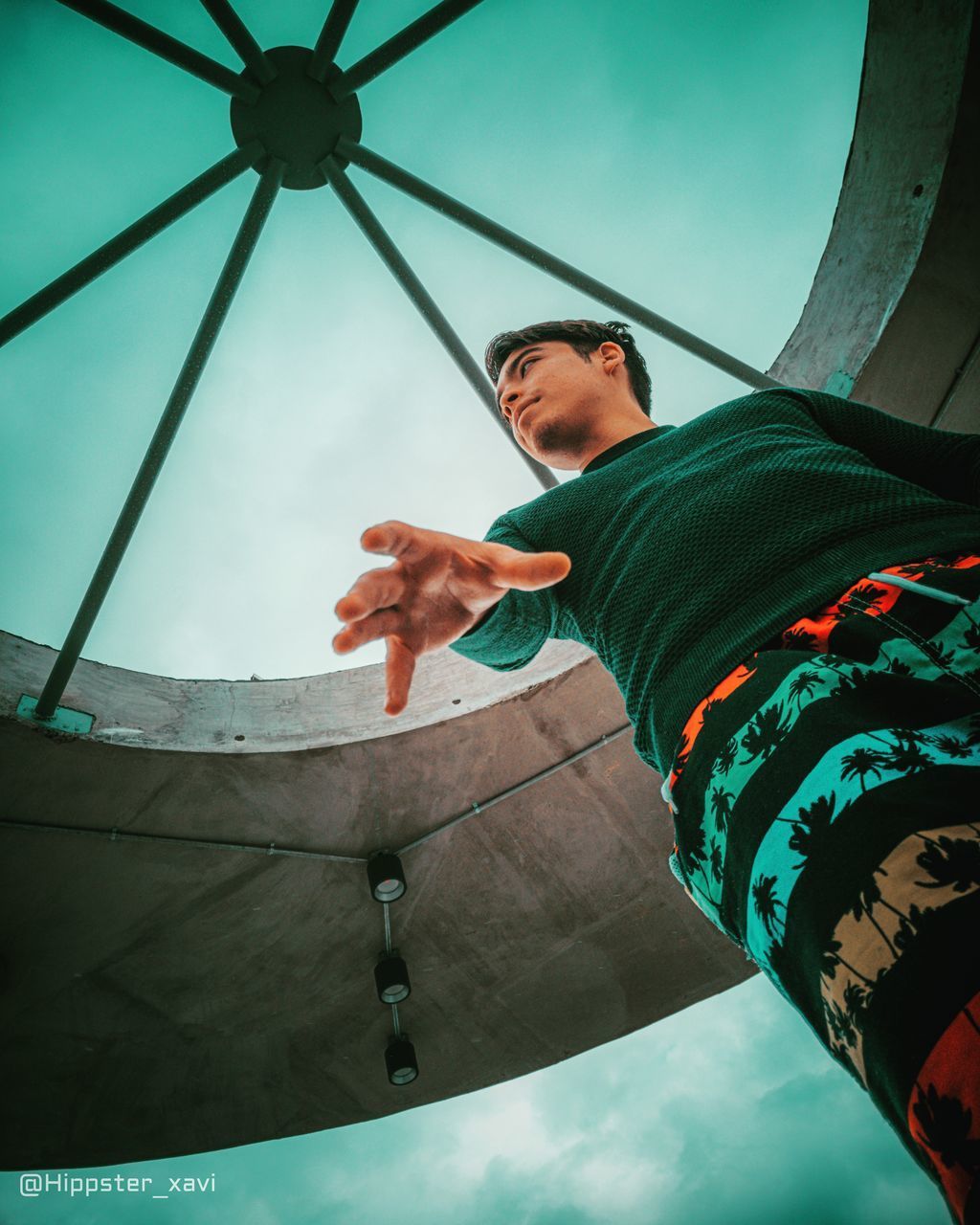 LOW ANGLE VIEW OF MAN HOLDING CAMERA AGAINST SKY